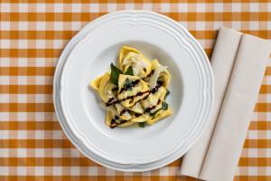 a white plate with pasta on a table at Hotel Mirandola in Mirandola