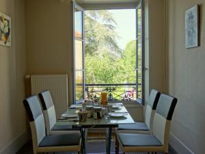 einen Esstisch mit Stühlen und ein großes Fenster in der Unterkunft B&B Girolles les Forges in Girolles