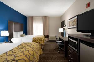 a hotel room with two beds and a flat screen tv at Baymont by Wyndham Casa Grande in Casa Grande