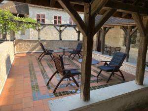 - un ensemble de chaises et de tables sur une terrasse dans l'établissement Demeure des Vieux Bains, à Provins