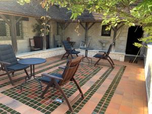 patio z krzesłami i stołami na patio w obiekcie Demeure des Vieux Bains w mieście Provins