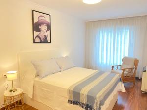 a white bedroom with a bed and a window at OH LA LIFE MAMMA MIA! in Noya