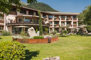 ein großes Gebäude mit einem Garten davor in der Unterkunft Hotel Theresia in St. Leonhard in Passeier