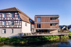 a building with a bridge next to a river at Sternen Bohlingen Aparthotel in Singen