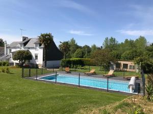 ein Schwimmbad in einem Hof neben einem Haus in der Unterkunft Tente Lodge les Gîtes de l'Odet in Lanio