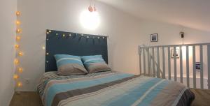 a bedroom with a bed with a black headboard and lights at KERWATT loft in Cabourg