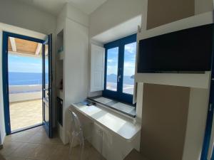 a room with a large window with a view of the beach at 'A Alera Room & Breakfast in Malfa
