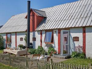 een rood-wit huis met een tafel ervoor bij 6 person holiday home in Nex in Neksø