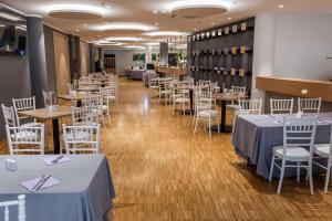 a dining room with tables and white chairs at Hotel Academia in Zagreb