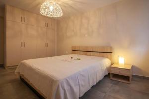a bedroom with a large white bed with a light at House on the beach in Salamina