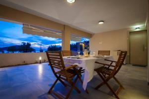 a dining room with a white table and chairs at House on the beach in Salamina