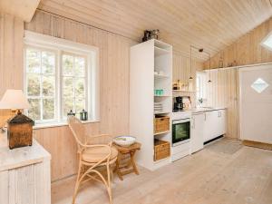 スケーエンにある4 person holiday home in Skagenの木製の壁のキッチン(テーブル、椅子付)