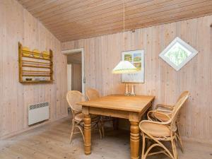 スケーエンにある4 person holiday home in Skagenのダイニングルーム(木製テーブル、椅子付)