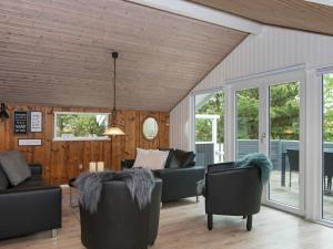 een woonkamer met banken en stoelen bij 6 person holiday home in R m in Bolilmark