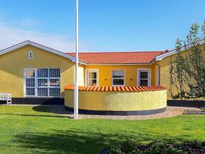 ein gelbes Haus mit einer Flagge im Hof in der Unterkunft Holiday home Skagen XXX in Skagen