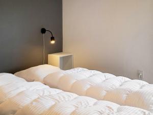 a bedroom with two white beds and a lamp at Holiday home Skagen XXX in Skagen