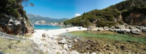 a beach with a group of people in the water at Sun's Gift Mini Studio in Paleokastritsa