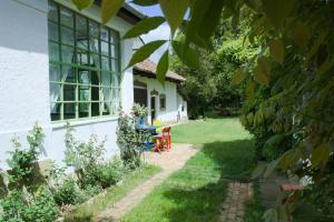 - un jardin avec une table et des chaises en face d'une maison dans l'établissement Dió-Lak Vendégház, à Feldebrő