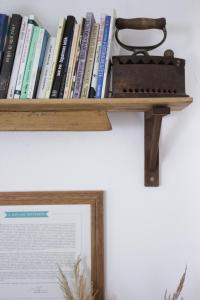 una estantería de madera con libros en la pared en Dió-Lak Vendégház, en Feldebrő