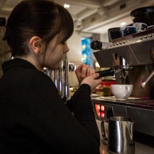 Una donna sta preparando il cibo in una cucina di Hotel Indigo Glasgow, an IHG Hotel a Glasgow