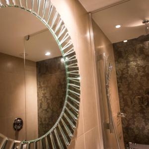 a bathroom with a mirror and a shower at Hotel Indigo Glasgow by IHG in Glasgow