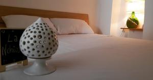 un vaso seduto su un tavolo accanto a un letto di La Nchioscia a Ostuni