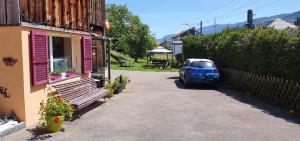 a blue car parked in a driveway next to a house at La Ferme des Fées in Bévilard