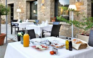una mesa con comida y bebidas encima en Hotel Urbisol, en Calders