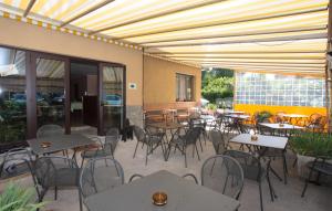 an empty patio with tables and chairs and a building at Orso Momo in Calizzano