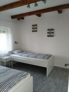 a white bedroom with a bed and a window at Exclusive Beachfront Villa in Fonyód