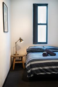 a bedroom with a bed and a table with a lamp at Wake Up! Bondi Beach in Sydney