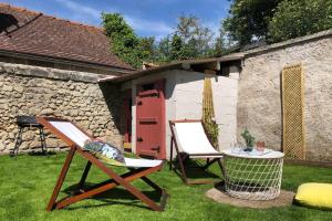 2 chaises et une table en face d'un bâtiment dans l'établissement Maison la Déco Verte, à Braine