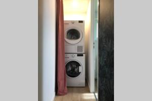 a laundry room with two washes and two machines at Maison la Déco Verte in Braine