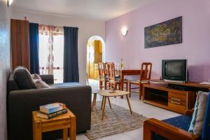 a living room with a couch and a tv at Apartamento Stª Eulália Deluxe by Umbral in Albufeira