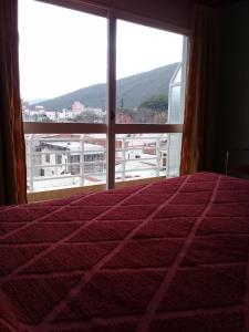 a bedroom with a bed and a large window at Apart Hotel Marilian in Salta