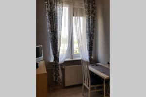 a room with a desk and a window with curtains at Apartament MORSKA 148 Gdynia 65m2 in Gdynia