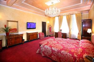 a large bedroom with a red bed and a chandelier at Vigo Hotel in Ploieşti