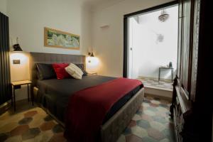 ein Schlafzimmer mit einem Bett und einem großen Fenster in der Unterkunft La Dimora sotto le Stelle in Noto