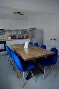 a kitchen with a wooden table and blue chairs at The Bear House in Buşteni