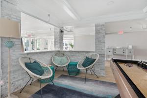 a billiard room with three chairs and a pool table at The Cove at Rockport in Rockport