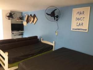 a living room with a couch and a sign on the wall at Vista Lateral Mar Massaguaçu in Caraguatatuba