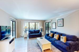ein Wohnzimmer mit einem blauen Sofa und einem TV in der Unterkunft Moorings 0910 in Hilton Head Island