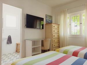 プンタ・ウンブリアにあるCasa Sanabria habitaciones privadas en una vivienda particularのベッドルーム1室(ベッド2台、デスク、テレビ付)