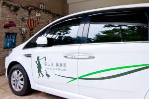 Une voiture blanche avec un panneau qui se prête à un ouragan dans l'établissement Villa of Permaculture, à Fengping