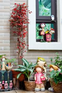 a group of figurines in front of a house with a plant at Villa of Permaculture in Fengping