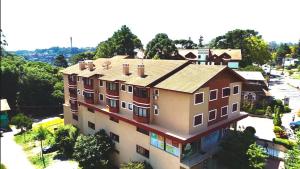 uma vista geral de um edifício numa cidade em GRAMADO SOLAR REAL - 2 APTS de 2 quartos no mesmo prédio, cada um comporta até 7 pessoas - IDEAL PARA GRUPOS - central - IDEAL PARA ANDAR A PÉ, nesta plataforma desde janeiro de 2016, oferecemos CREDIBILIDADE - seu PET é bem-vindo - GARAGEM COBERTA em Gramado