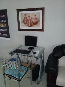 escritorio con ordenador y silla en una habitación en Apart Hotel Marilian en Salta