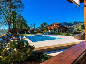 a swimming pool in a yard with a wooden table at Pousada Viver a Pedra in Gonçalves