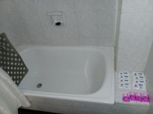 a white bath tub in a bathroom with pink bottles at Apart Hotel Marilian in Salta