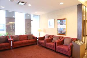 a waiting room with red chairs and windows at Hotel Hokke Club Hiroshima in Hiroshima